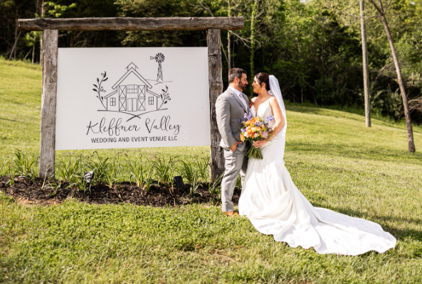 bride and groom beside kleffner valley sign